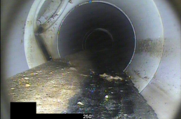 PVC sewer pipeline with mineral deposits before removal with water blast